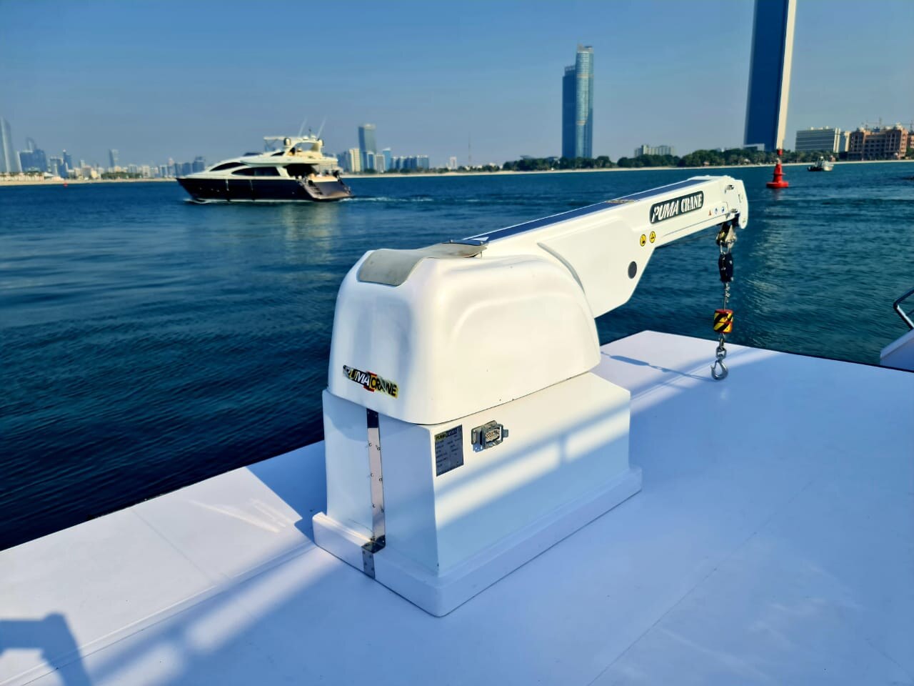 Puma crane on yacht deck in harbor